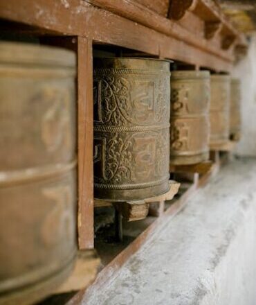 Rustic Buddhist prayer wheels at a monastery in Leh, India.